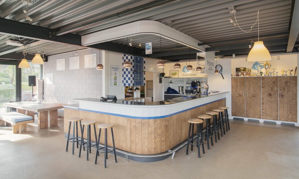 Hoekbar van berken multiplex voor tennisvereniging De Aeronauten in Den Haag, met een naadloos blad van Krion solid surface | maatwerk van Luc en Roel, Rotterdam