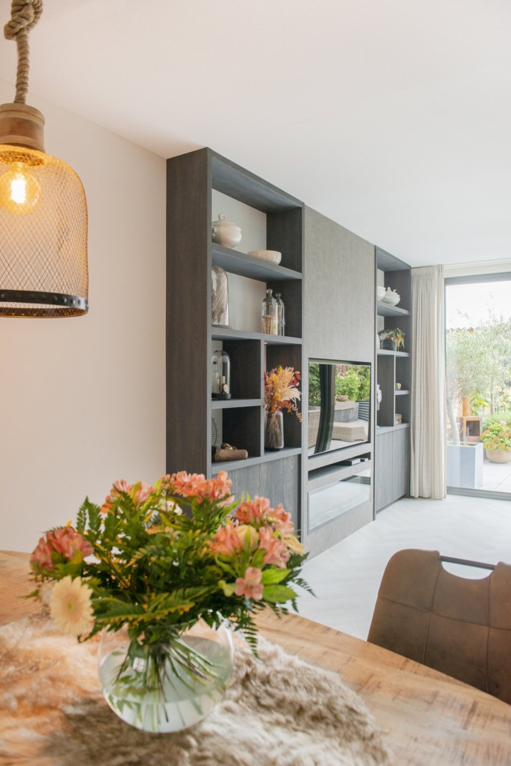 Cinewall van luxe spaanplaat in een donkere houtlook, met plek voor tv en haard in één wand | maatwerk van Luc en Roel, Rotterdam