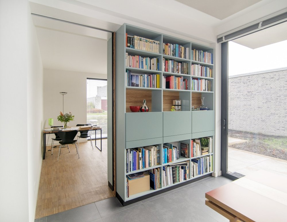 Dubbelzijdige boekenkast als roomdivider, aan beide kanten open vakken vol boeken | maatwerk van Luc en Roel, Rotterdam