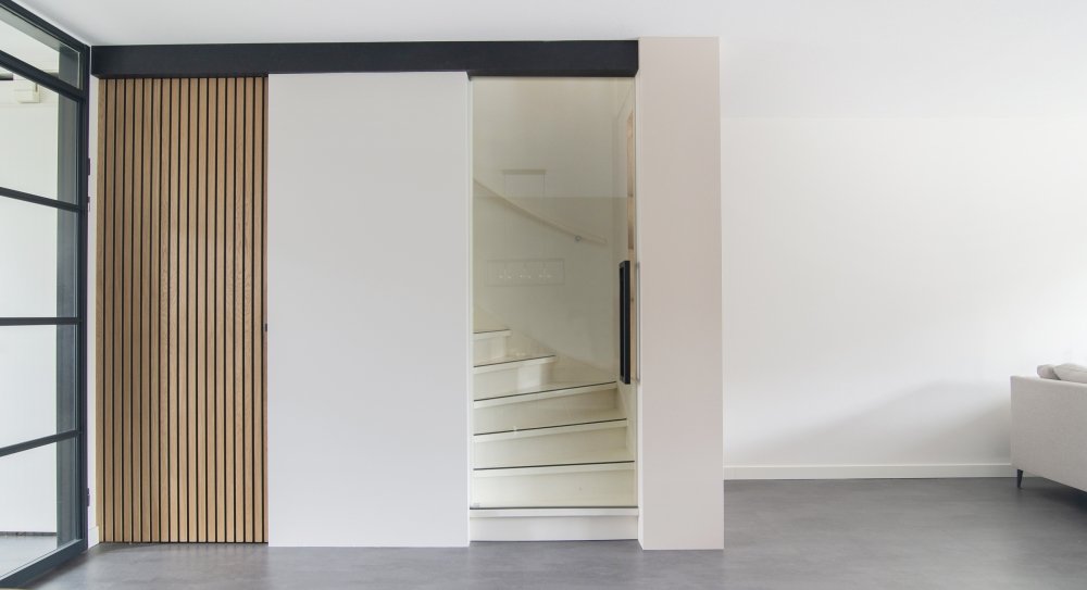 Trapombouw met een grote schuifdeur en een wand van verticale houten latten | maatwerk van Luc en Roel, Rotterdam