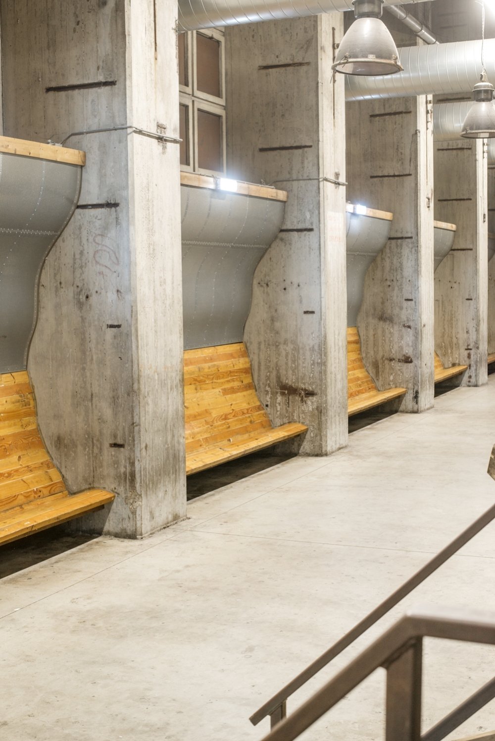 Zitbanken gemaakt van oude kabelhaspels: houten zittingen met een gebogen metalen rug, op maat gebouwd voor hun plek | maatwerk van Luc en Roel, Rotterdam