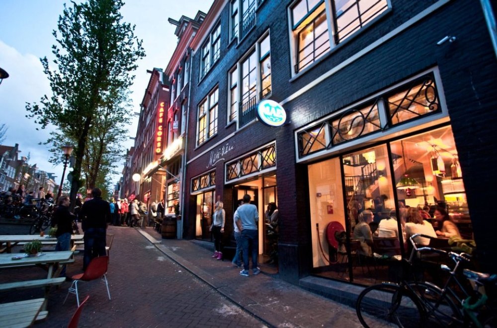 Interieurbouw voor café-restaurant Mata Hari: een warm horeca-interieur over twee verdiepingen, met bar en een vide met spijlenhekwerk | maatwerk van Luc en Roel, Rotterdam