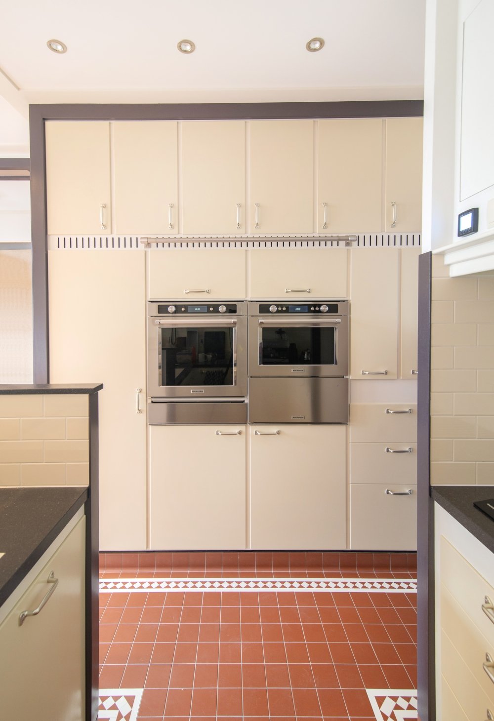 Keuken op maat in de stijl van de klassieke Piet Zwart keuken: crèmekleurige fronten met donkere kaders en een kastenwand tot het plafond, compleet met ladder | maatwerk van Luc en Roel, Rotterdam