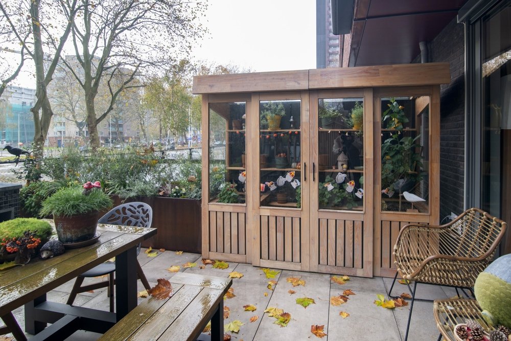 Tuinkas van robiniahout op het terras: glazen wanden, schappen voor de planten en een uitzetraam op rvs-uitzetters | maatwerk van Luc en Roel, Rotterdam